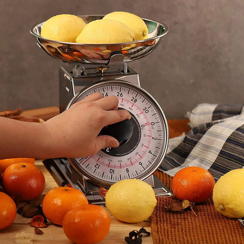 Hand adjusting dial on 2 Pound Analog Food Scale With 32 Ounces Capacity Stainless Steel Mechanical Kitchen Scale Removable Bowl Tare Function Retro Style Easy Clean Durable Classic Design For Precise Portions