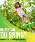 Child playing on Stand Up Tree Swing For Kids With Adjustable Handles, Surf Style Kick Swing, Easy Install Outdoor Swingset, Green