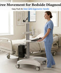 Adjustable Height Rolling Standing Desk With Rock Solid Monitor Mount And Smooth Keyboard Tray, Mobile Sit Stand Workstation Cart in clinical setting.