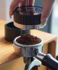 Slick 58mm Coffee Distributor Needle With Geared Spinning Action And Sturdy Black Base, Smooth Espresso Leveler For Flawless Puck Prep, Legit Home Barista Essential Brewing Gear, user preparing ground coffee.