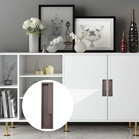 Zinc Alloy Flush Pull Handles Set Of 2 For Sliding Doors And Drawers in brown, installed on a modern white cabinet with decorative items on top.
