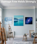 Heavy Duty Drywall Canvas Hangers And Claw Hooks Damage Free Picture Hanging Kit displayed in a bright studio with paintings.