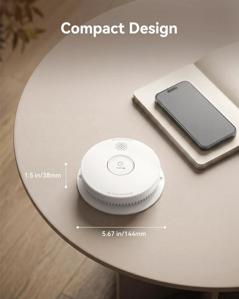 10 Pack Photoelectric Smoke Detectors Hardwired And Interconnected With 9V Battery Backup on a table by a smartphone, showcasing compact design.