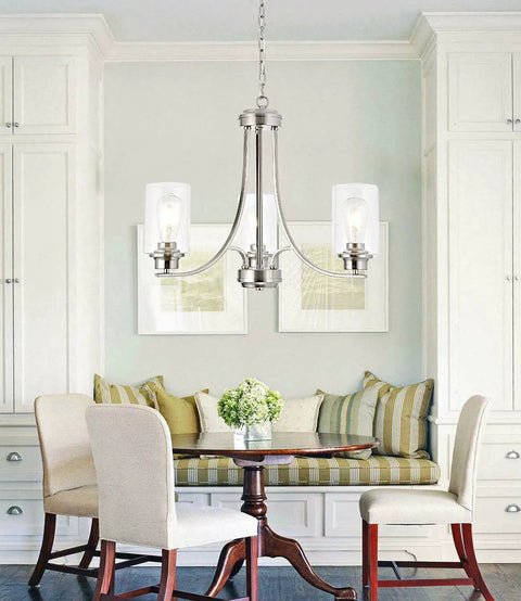 Three-Light Brushed Nickel Chandelier With Clear Glass Shades in a cozy dining area with white cabinets and a wooden table