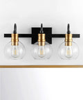 21.5 Inch Black And Brass Gold Vintage Wall Sconce With Clear Glass Globe Shade above a mirror