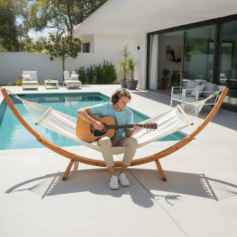 Wood Arc Hammock Stand With Double Hammock For Outdoor Use Natural Wooden Frame Supports Up To 330 Lbs 14 Feet Long Heavy Duty Chains And Carabiners Included Chill All Weather Lounging by a poolside.
