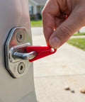 Hand placing Heavy Duty Silicone Car Door Lock Buffer Pads For Hella Quiet Drives And Zero Rattle on vehicle latch.