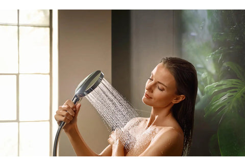Woman using Raindance Select S Adjustable 5 Inch Handheld Shower Head Set with PowderRain spray in bathroom
