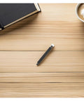 Plastic Bearing Roller Pinch Feed Shaft For Barcode Label Printer Replacement Part on a wooden table next to a notebook and coffee.