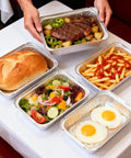 60 Pack Aluminum Foil Pans With Lids, 8.5 By 6 Inch, 2.25 Lb Capacity, filled with meals on table including steak and salad