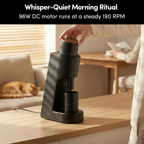 Rock Solid Single Dose Coffee Grinder With Brawny 38 Mm Conical Burrs And Butter Smooth Stepless Dial For Bold Espresso Pour Over Pulls Low Retention Anti Static Frame In Matte Black on kitchen table with user adjusting dial.