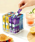 No Sweat Spin Lazy Susan Drink Packet Organizer Square Four Compartment Pantry Turntable holding flavor drink packets on countertop.