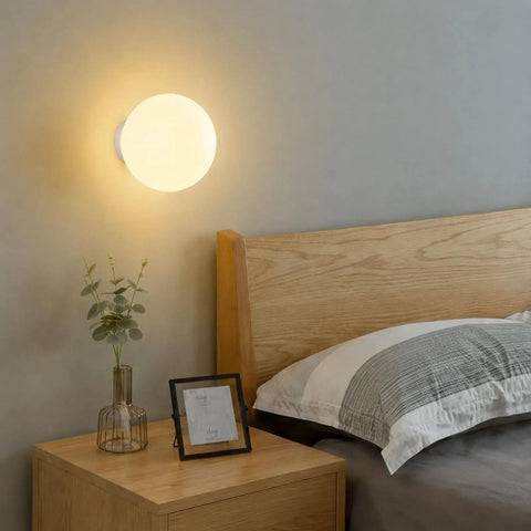 Minimalist Globe Wall Sconce, 1-Light White E27 Round Wall Light Fixture above a bed in a cozy modern bedroom.