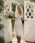 A woman with a bouquet of pink roses walking through white courtyard gates with Heavy Duty Gate Hinges With One Piece Cast AISI 304 Stainless Steel Left Handed Sliding Bolt Latch And Adjustable Silent Pads For Vinyl Gates Farm Fence Gates Courtyard Gates Wood And Iron Fences.