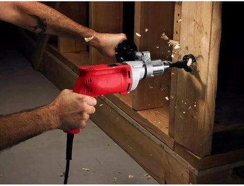 Heavy Duty Corded Power Drill With Beast Mode 8 Amp Motor Delivering Up To 850 Rpm And Variable Speed Trigger Plus Rotating Side Handle And Keyed Chuck drilling into wood.