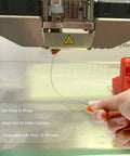 Hand using needle from 3D Printer Nozzle Cleaning Kit 13 Piece Set With 0.4mm Cleaning Needles to clear blockage on 3D printer nozzle