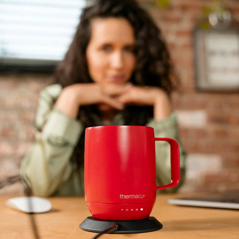 Grab This Solid Self Heating Coffee Mug To Keep Your Morning Sips Piping Hot With Smart Temperature Controls And A Ridiculously Long Battery Built From Premium Stainless Steel For Office Or Travel Cherry Red on a table.