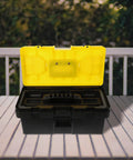 Badass Stackable Plastic Toolbox With Slick Removable Tray And Padlock Buckles open on a wooden surface, showcasing its interior.