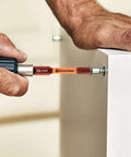 Close-up of Amartisan 5mm hex bit, S2 steel with magnetic tip, held in a drill near a white door frame.