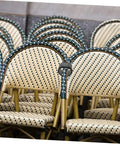 Stacked wicker patio chairs in a row, showcasing woven design and sturdy frames, ideal for outdoor settings.