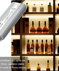 60W Waterproof IP67 LED Power Supply From AC100-264V To 12V DC 5A Transformer for LED lighting installation shown next to backlit bottles
