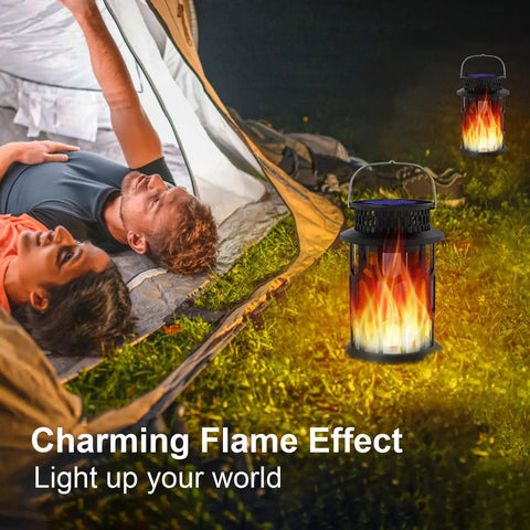Outdoor Solar Lanterns With Realistic Flickering Flame illuminating tent area on grass with couple resting nearby, 2 Pack