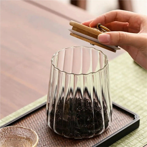 Level Up Your Kitchen With This Tough Clear Glass Storage Jar Boasting A Tight Airtight Wooden Lid Sealed Cap For Grains Coffee Beans Candy And Spices To Keep Everything Fresh On Hand, showing tea being stored.