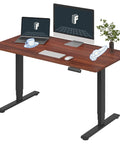 Spacious Flexispot Electric Standing Desk With Dual Motor Three Stage Lift And Memory Presets 55 By Twenty Eight Inches Whole Piece Mahogany Desktop Black Frame home office setup with two monitors and accessories.