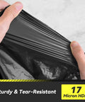 Hands stretching 100 Count 55 To 60 Gallon Black Trash Bags Heavy Duty Tear Resistant And Extra Sturdy Commercial Can Liners