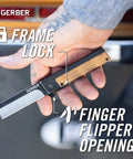 Hand holding Quadrant Clip Folding Knife with bamboo handle, showing frame lock and flipper opening mechanism.