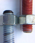 Close-up of two metal bolts, one wrapped with Copper Anti Seize Tape For Threads Three Quarters Inch By Fifty Feet PTFE Resin With Metal Flakes
