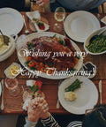 Thanksgiving dinner table with turkey, mashed potatoes, green beans, and people holding hands, featuring 'Wishing you a very Happy Thanksgiving' text