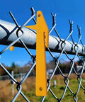 Chain Link Banana Clip Tool Pack For Fence Installation, Top Rail Clamp And Mesh Tensioner hanging on chain-link fence