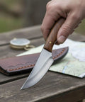 Person holding a Full Tang 4.75 Inch Hunting Knife With Burlwood Handle, Slim Camping Knife Featuring Stainless Steel Drop Point Blade And Sheath.