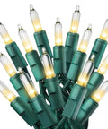 Close-up of Clear 300 Count Christmas String Lights on green wire, warm white bulbs for indoor outdoor use on trees, patios, fences.