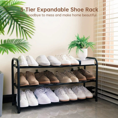 Expandable Three Tier Metal Shoe Rack For Entryway Closet And Doorway Free Standing Heavy Duty Organizer Holds Up To Twelve Pairs Of Shoes Easy To Assemble Space Saving Black with shoes displayed in room corner.