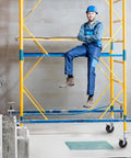 Man sitting on scaffolding with 5 Inch Scaffolding Casters Set of 2 With Dual Locking Brakes, heavy duty build visible.