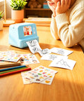Rock This Slick AI Voice Mini Thermal Printer With Bright Display And Awesome Creative App For Kids Speech To Line Art Drawing Anime Sketch And Hype Storytelling Portable Prints in use on a desk with sketches.