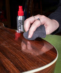 Person using microfiber cloth to polish guitar with Complete Guitar Care Kit And Clean Polish Set With Fretboard Conditioner Three Premium Microfiber Cloths Zero Grease Formula Built For Acoustic Or Electric Axes Pumping Crisp Gloss All Day Long.