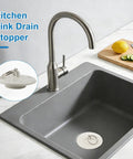 Six Size Universal Drain Stopper Set With Pull Ring Rubber Sink Plugs For Kitchen Bath Laundry And Tub That Easily Fits Seven Eighths Inch To Two Inches Across Six Sizes White in a kitchen sink.