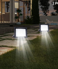 LED Work Light 100W 8000LM Flood Light Outdoor IP66 Weatherproof Plug in illuminating a backyard at dusk with 2 units.