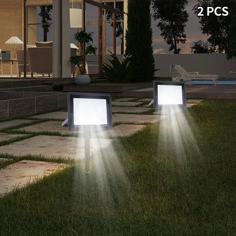 LED Work Light 100W 8000LM Flood Light Outdoor IP66 Weatherproof Plug in illuminating a backyard at dusk with 2 units.