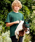 Child holding a hobby horse with brown hobby horse bridle with padded leather and lambswool reins and metal bit educational toy for kids 8 plus fits hobby horse tack realistic tacking practice and skill building for little riders
