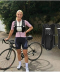 Woman in Lightweight Unisex Running Vest with Phone Pocket and Hydration Pack next to a bicycle outdoors.