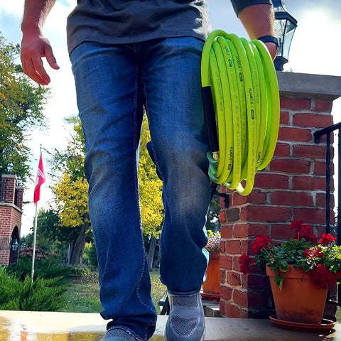 Person carrying Pressure Washer Hose With M22 Fittings, 1/4 In By 25 Ft, ZillaGreen Flexible Hybrid Polymer, Cold Water Only Up To 3100 Psi