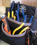 Front view of Klein Tools tool bag with blue and yellow pliers and screwdrivers