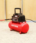 2 Gallon Portable Air Compressor With Knockout Oil Free Motor Delivering A Steady 125 Psi Through A Tough Hot Dog Tank on a workshop floor.