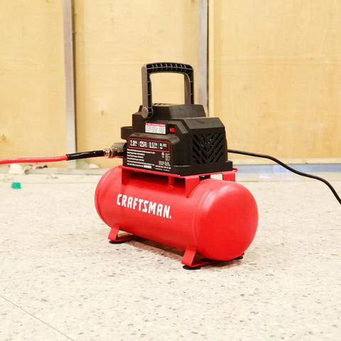 2 Gallon Portable Air Compressor With Knockout Oil Free Motor Delivering A Steady 125 Psi Through A Tough Hot Dog Tank on a workshop floor.