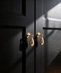 Top Shelf Heavy Duty Solid Brass Cabinet Knob Featuring Slick Brushed Gold Finish on black cabinet doors.