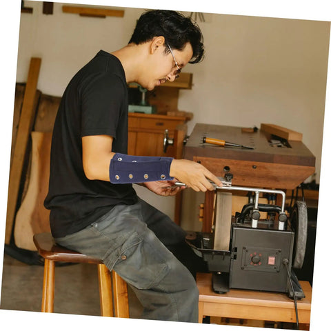 Man using a tool with Heavy Duty Cut Resistant Wrist Sleeves For Men And Women Beefy Arm Guards featuring abrasion block cover.